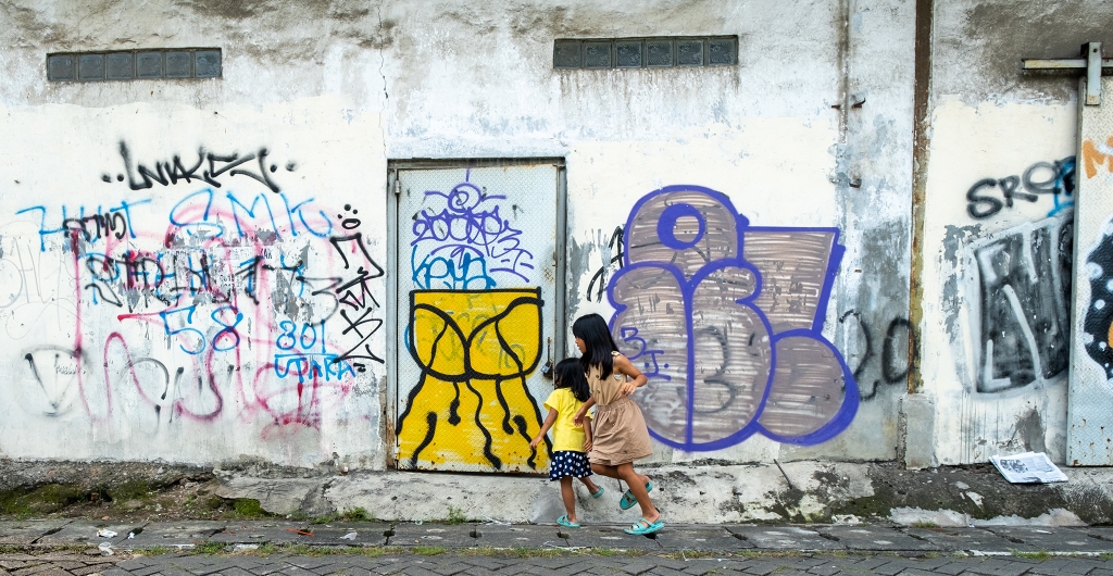 Two Girls at Play, with Graffiti, Jakarta, Java, Indonesia